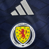 Scotland national team logo on a sports jersey with Adidas branding.