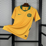 Yellow sports jersey with a logo on a hanger against a wire mesh background