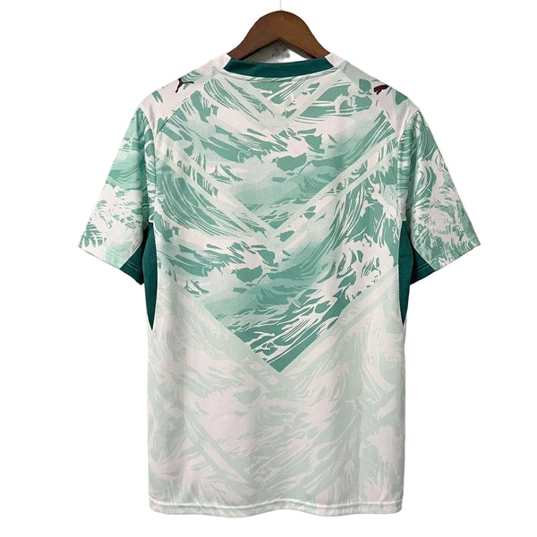 Green and white patterned shirt on a hanger against a gray background