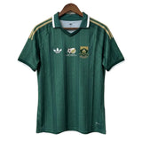 Green sports jersey with Adidas logo on a hanger against a plain background