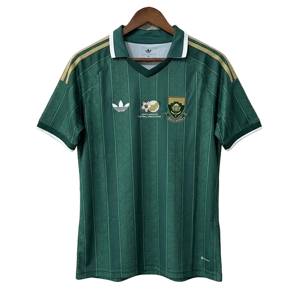 Green sports jersey with Adidas logo on a hanger against a plain background