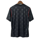 Black t-shirt with star pattern on a wooden hanger against a white wall