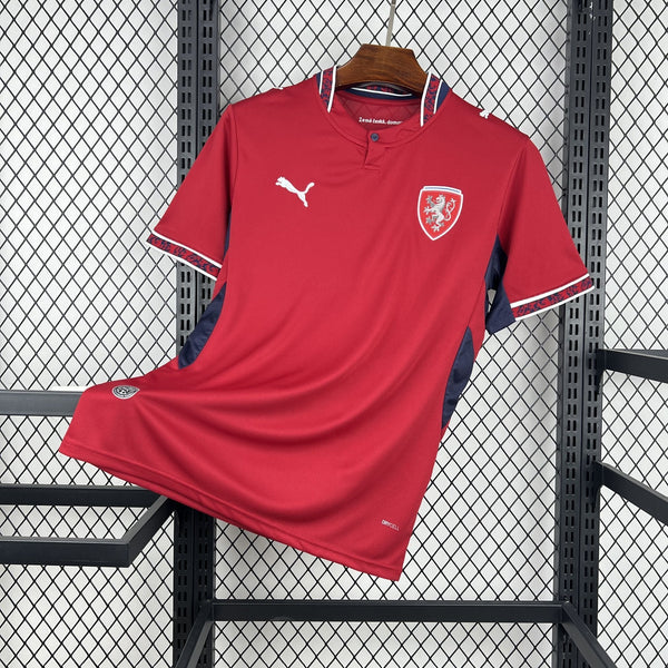 Red sports jersey with a logo on a hanger against a wire mesh background