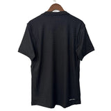 Black t-shirt on a hanger against a white wall